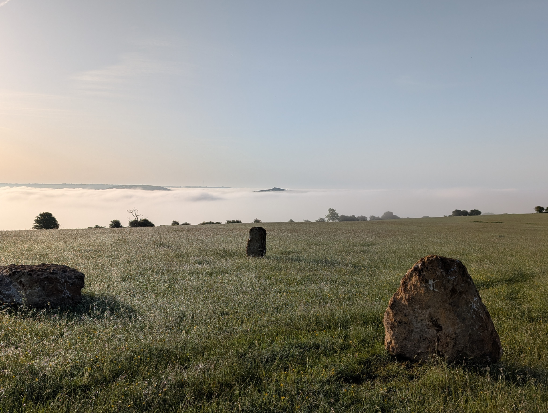 Stone circle at dawn above a sea of cloud over the Somerset Levels